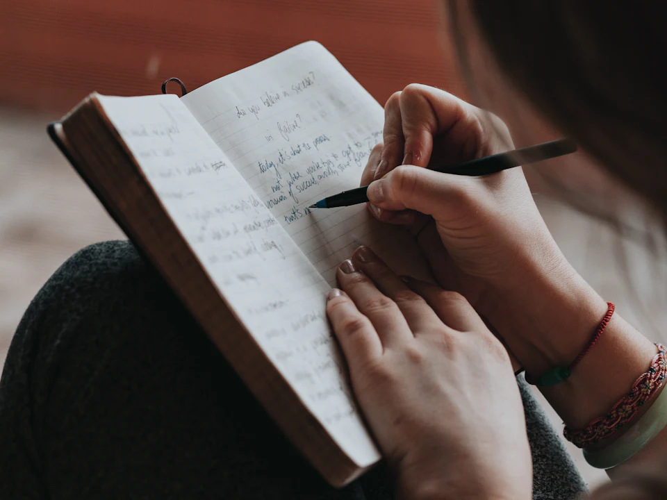 Una persona escribe a mano en un cuaderno.